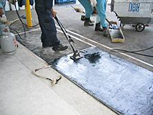 羽田空港内の格納庫前で、段差修正のために使用されたファルコン（高弾性アスファルト混合物）。（2003年）